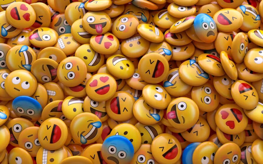 Tanti bottoni con faccine emoji felici, tristi o sorprese sono mescolati insieme.