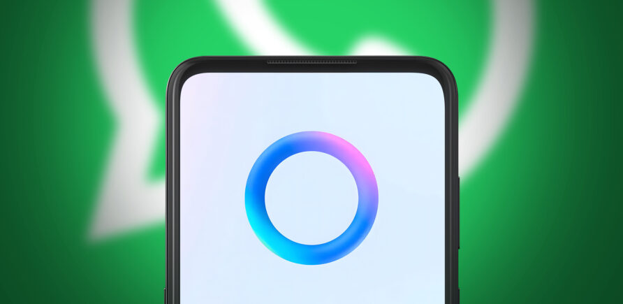Ein Smartphone zeigt den blauen Kreis von Meta AI. Im Hintergrund ist unscharf das WhatsApp-Logo zu erkennen.