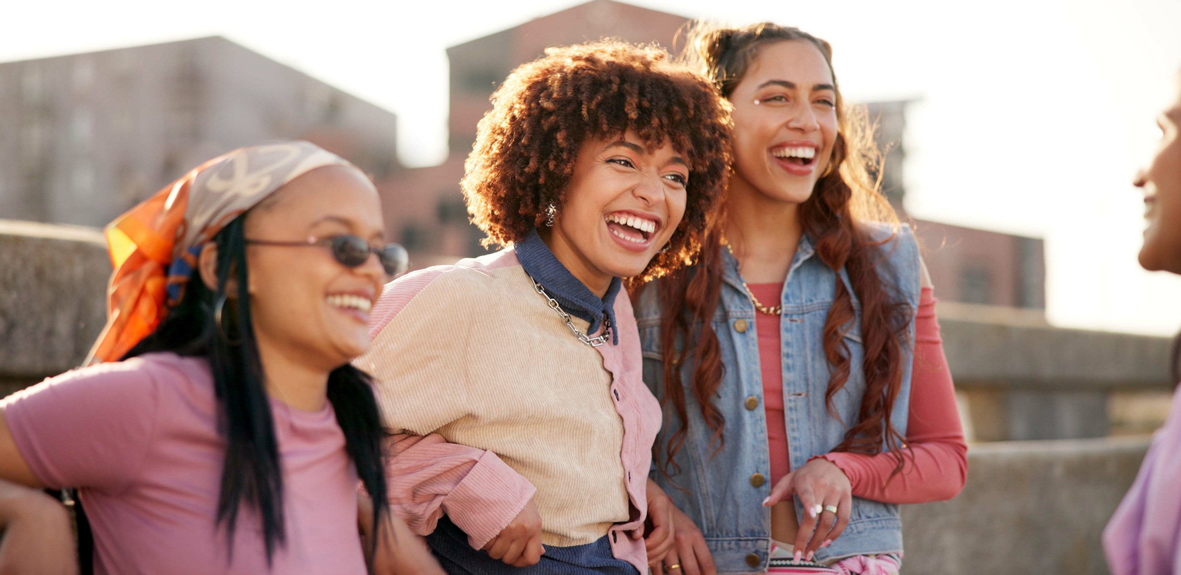 Eine Gruppe junger Menschen lacht und unterhält sich im Freien.